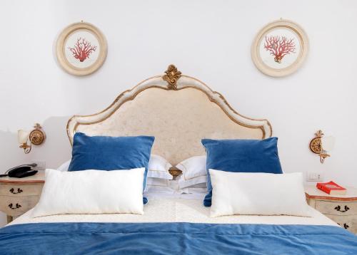 a bedroom with a bed with blue and white pillows at Hotel Onda Verde in Praiano