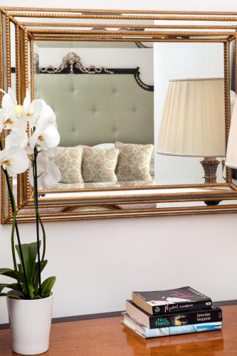 a table with a vase of flowers and a mirror at Hotel Onda Verde in Praiano