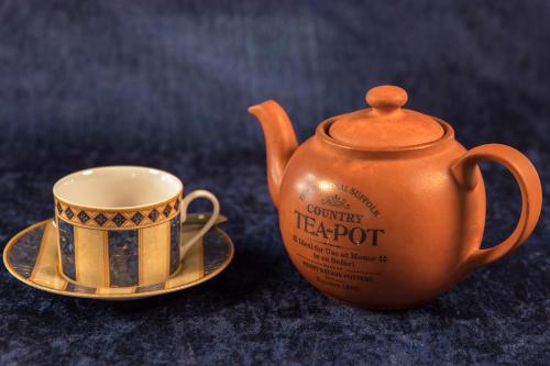 an orange tea pot and a cup on a saucer at Bed & Breakfast Horsens in Horsens