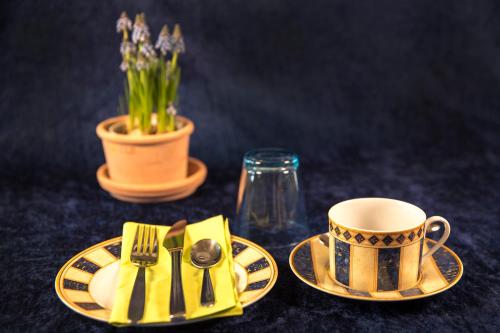 a table with a plate with a fork and a coffee cup at Bed & Breakfast Horsens in Horsens