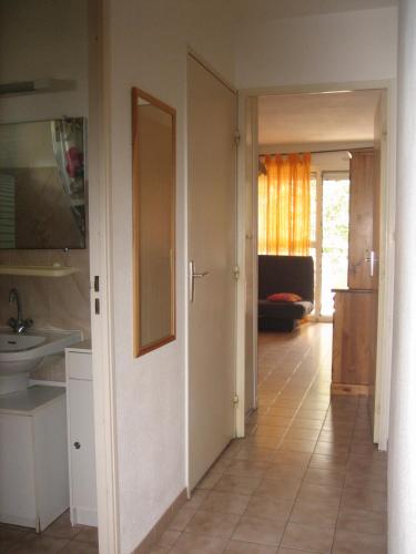 une cuisine avec un couloir doté d'un évier et d'une porte dans l'établissement 84 Rue du Vieux Village, à Carnon-Plage