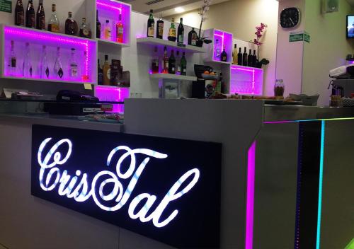 a bar with a neon sign on the counter at Cristal Rooms in Piacenza