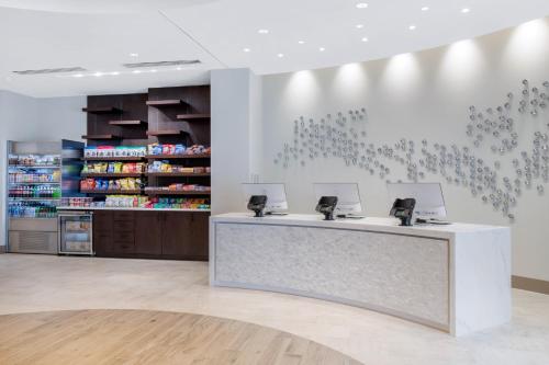 a pharmacy counter with two computers on a wall at Cambria Hotel College Park in College Park