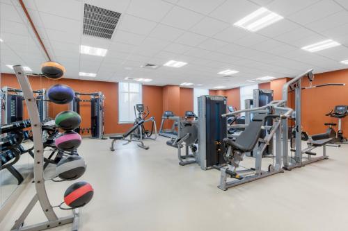 a gym with several treadmills and cardio machines at Cambria Hotel College Park in College Park