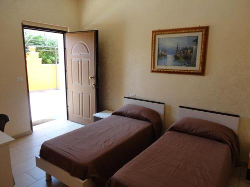 a room with two beds and a door with a door at Anema e Core Pizzo in Pizzo