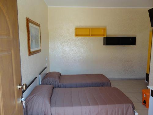 a room with two beds in a room with a door at Anema e Core Pizzo in Pizzo