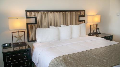 a large bed in a hotel room with two lamps at San Simeon Lodge in San Simeon