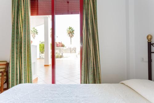サンルーカル・デ・バラメダにあるBonito apartamento en campo de golf con piscinaのベッドルーム1室(ベッド1台付)が備わります。パティオの景色を望めます。