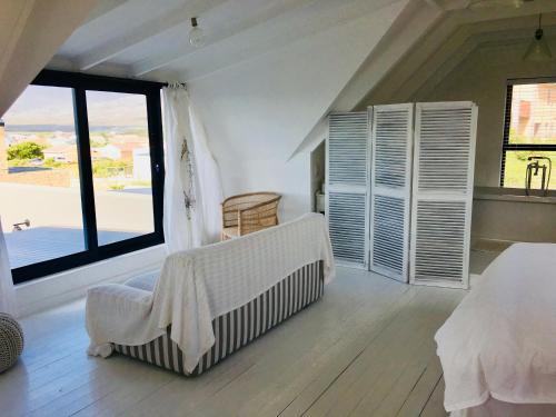 a bedroom with a bed and a large window at Pringle @ 865 Jally in Pringle Bay