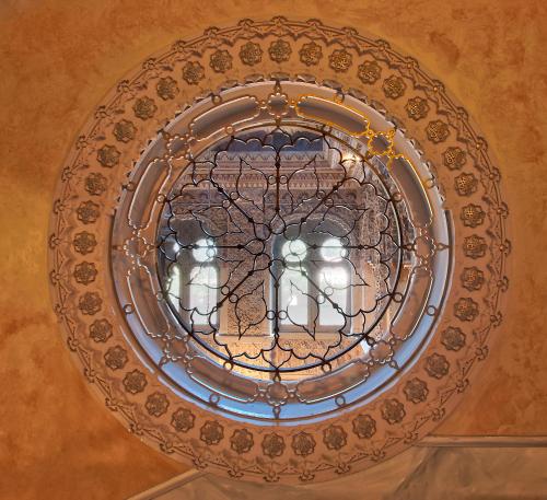 a chandelier with three statues on a ceiling at Relais & Chateaux Villa Crespi in Orta San Giulio