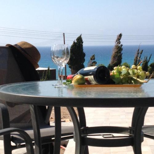 a table with a plate of food and a wine glass at Pomos Idol Exceptional Beach Villa in Pomos