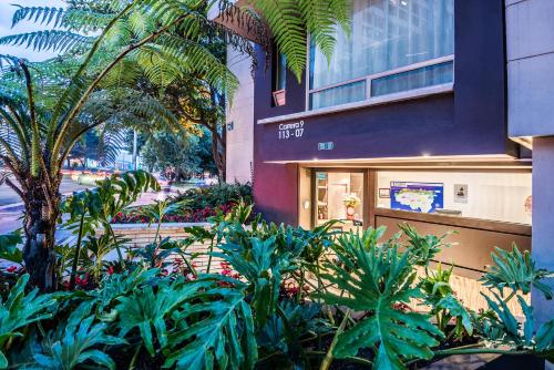 a building with a bunch of plants in front of it at Hotel Viaggio Teleport City Suites in Bogotá