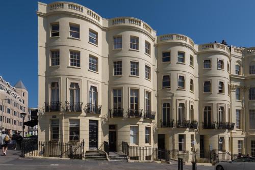 a white building with people walking in front of it at Brunswick Patio Apartment by MyHolidayLet in Brighton & Hove