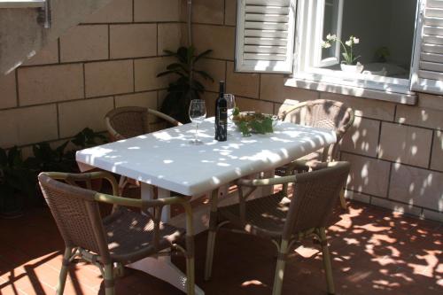 a table with chairs and a bottle of wine on it at Apartment Dubcic: For perfect vacation in Dubrovnik