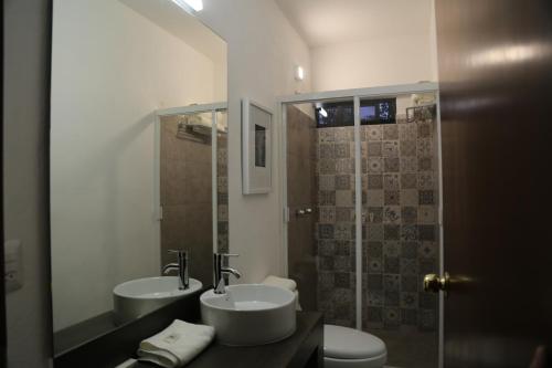 a bathroom with two sinks and a shower at Casa Massima Hotel in León