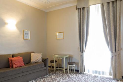 a living room with a couch and a window at Hotel Alpi Resort in Turin