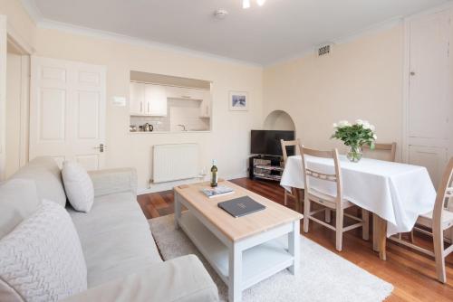 a living room with a couch and a table at Brunswick Patio Apartment by MyHolidayLet in Brighton & Hove