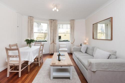a living room with a couch and a table at Brunswick Patio Apartment by MyHolidayLet in Brighton & Hove