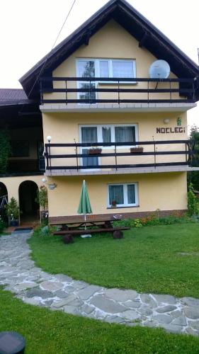 a house with a green umbrella in front of it at Agroturustyka Grazyna Ksel Korbielow ul slepa dolina 2 in Korbielów