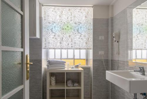 baño con lavabo y ducha con ventana en Hotel Alpi Resort, en Turín