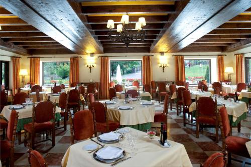 un comedor con mesas, sillas y ventanas en Parador de Fuente Dé, en Fuente Dé