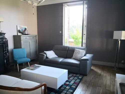 un salon avec un canapé et une table basse dans l'établissement maison courbarien, à Saint-Georges-la-Pouge