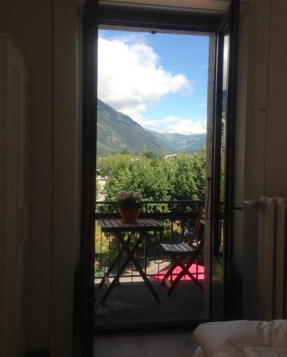 a view from the door of a balcony with a table and chair at Appartement Alexandra in Chamonix-Mont-Blanc