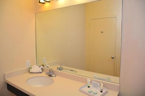 a bathroom with a sink and a large mirror at Sunchase Inn & Suites in South Padre Island
