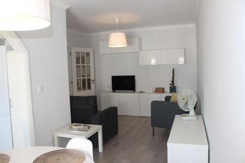 a white living room with a couch and a table at Vigia's Guest House in Viseu