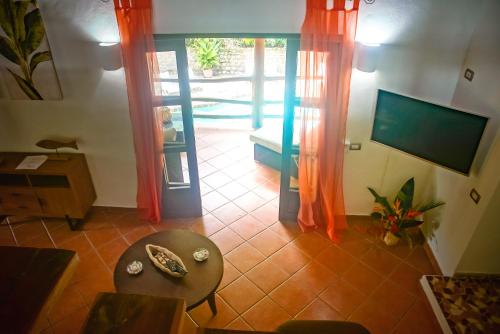 a living room with a table and a television at Manala Hotel in Santa Teresa Beach