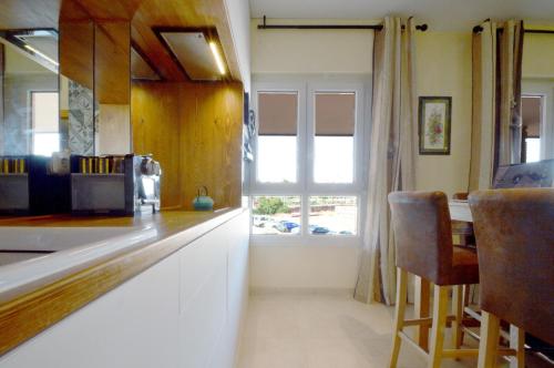 a kitchen with a counter and a window at Moderno apartamento frente a la playa y el centro in Almería