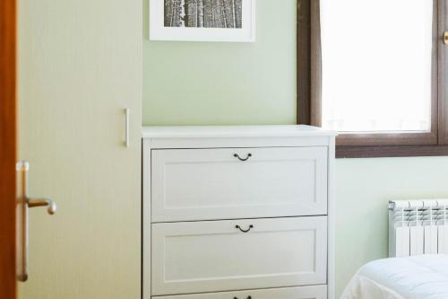 a white dresser in a bedroom with a window at Apartamento Garona in Les