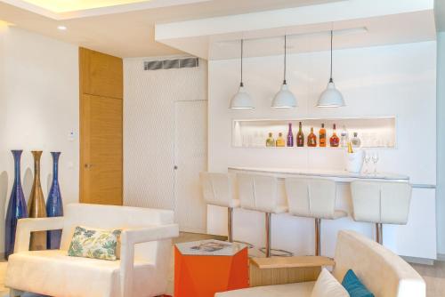 a living room with a bar with white chairs at Breathless Montego Bay Adults Only - All Inclusive in Montego Bay
