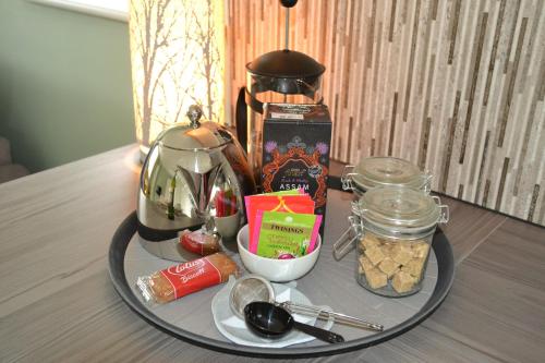 a tray with a tea pot and food on a table at Little Dene Apartment in Salisbury