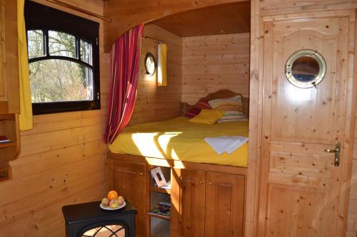 a bedroom with a bed in a log cabin at La Maison de l'Omignon in Vermand