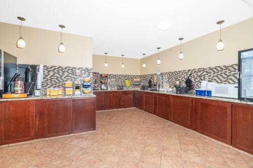 a large kitchen with wooden cabinets and a counter at Days Inn by Wyndham Faribault in Faribault
