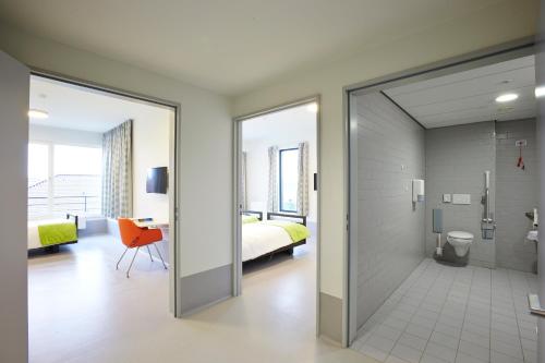 a bathroom with a sliding glass door leading to a bedroom at Hotel Middelpunt - Gratis Parking - Ontbijt inbegrepen! in Middelkerke