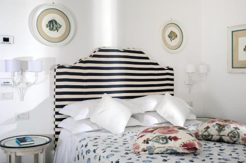 a bedroom with a bed with a striped headboard and pillows at Villa Corallium in Praiano