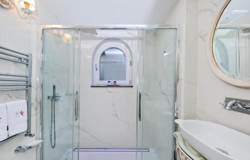 a bathroom with a shower and a sink and a mirror at Villa Corallium in Praiano