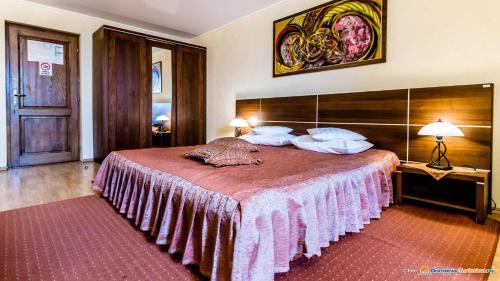 a bedroom with a large bed with a pink blanket at Valea Regilor Reghin in Reghin