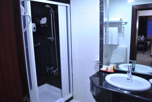 a bathroom with a sink and a shower and a toilet at Larsa Hotel in Amman