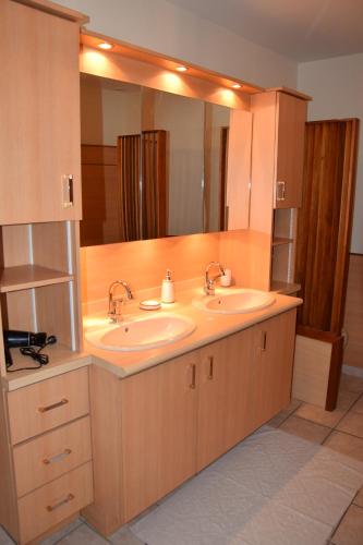 une salle de bain avec deux lavabos et un grand miroir dans l'établissement Moulin des Gypses Gîte Les Pierres Blanches, à Mormoiron