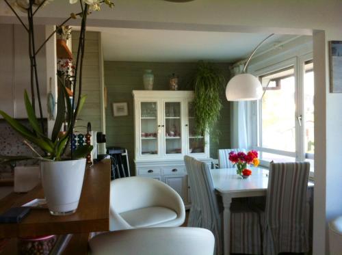 una cucina e una sala da pranzo con tavolo e sedie di Appartement Vue Mer Benerville-sur-mer a Bénerville-sur-Mer