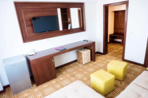 a room with a tv and a table and stool at Hotel Bucovina in Suceava