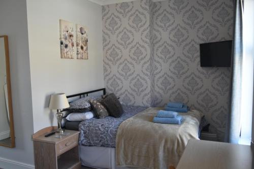 a bedroom with a bed and a tv on a wall at Adelaide Apartments 2 in Blackpool