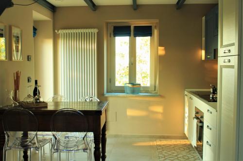 eine Küche mit einem Tisch und Stühlen sowie einem Fenster in der Unterkunft La Basiglia Apartment in Monforte dʼAlba