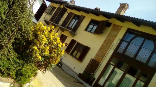 a yellow house with a tree in front of it at Al Calar Della Sera in Sommariva del Bosco