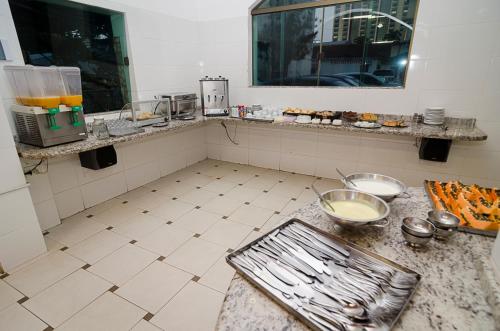 a kitchen with a counter with food on it at Hotel Indaiá in Maringá