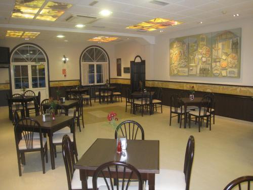 a dining room with tables and chairs in a restaurant at Hotel y Casona El Carmen in Perlora