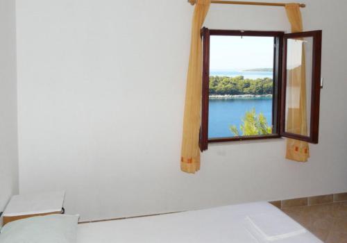 een kamer met een raam met uitzicht op een meer bij Apartments near the sea Marinovic in Prizba